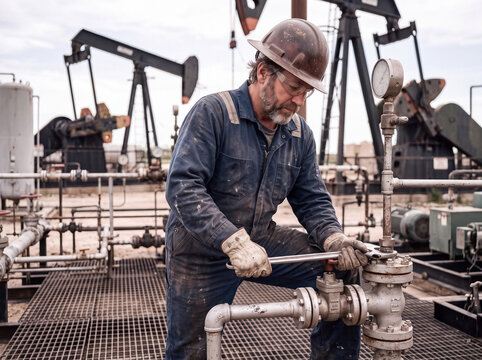 Oil worker service valve at petroleum extraction site