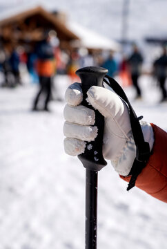 Skier gripping pole at snowy mountain resort