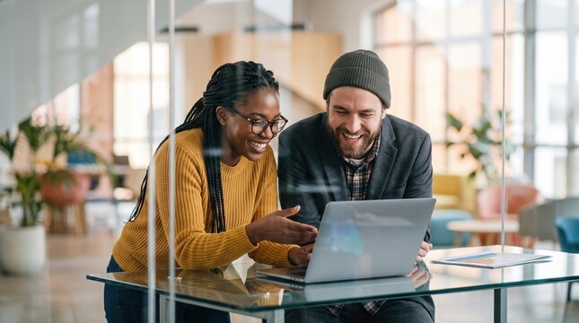 Coworkers collaborate on laptop project in modern office