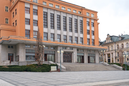 Facade of the New Town Hall in Jablonec nad Nisou, Liberec Region, Czech Republic, with its orange functionalist architecture, tall windows and paved square.