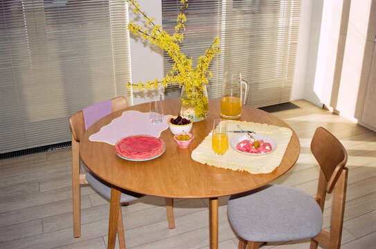 Colorful table setting with drinks and pink pancakes.