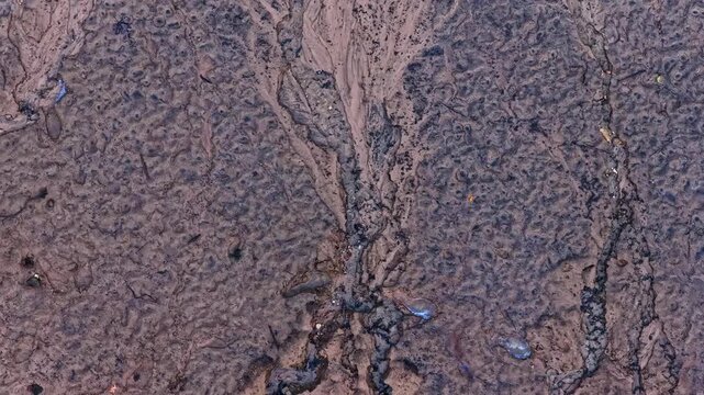 Top-down aerial view of contaminated soil with toxic waste and chemical pollution flowing