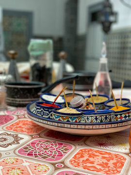 Colorful Moroccan spices in the traditional Marrakech kitchen, in patterned bowls on a table