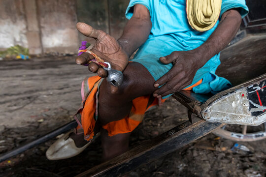 Hand of a rickshaw puller holding a small metal bell tied with colorful thread beside the rickshaw, West Bengal, Kolkata, India