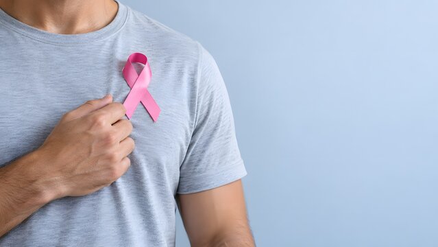 Close up of male chest with pink ribbon symbol for breast cancer health campaign