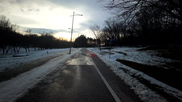 Snowy Park Path Curving Toward Winter Sunset