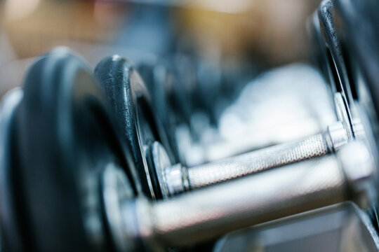 Close-up of dumbbell row on gym rack with blur background