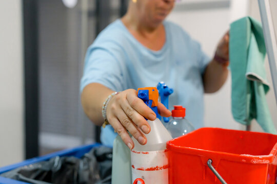 House cleaner with spray bottle and mop bucket