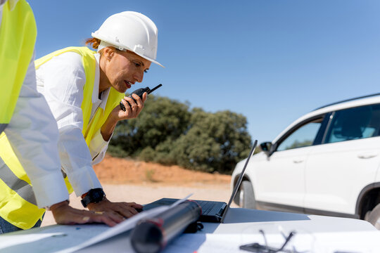 Female engineer review wind turbine data at remote site