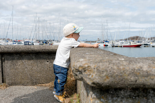 Child point toward boat at Howth Harbour, Dublin, Ireland