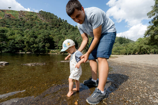 Father help toddler explore Upper Lake in Glendalough