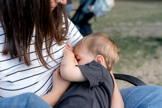 Mother breastfeeding baby outdoors in Dublin Park