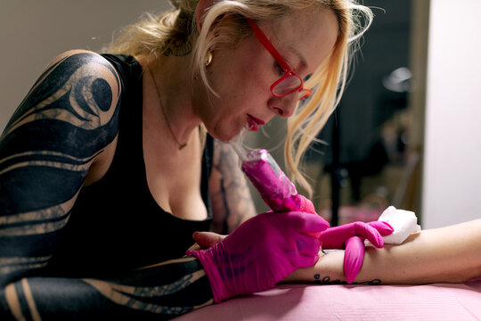 Tattoo artist prepares woman for body art session