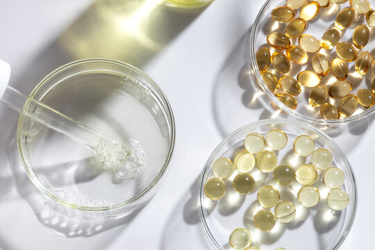 Golden gel capsule and glassware in caustic light