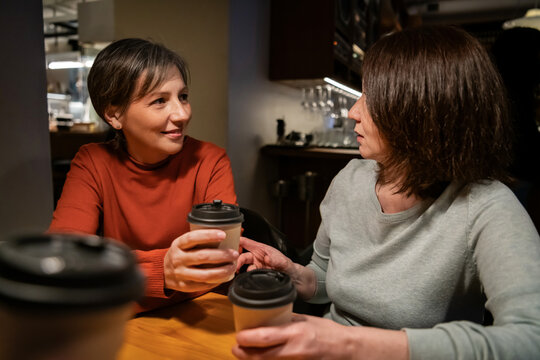 Mature women share coffee and conversation at cafe