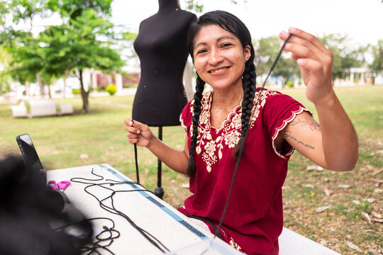 Artisan woman creating handmade macrame textile outdoors