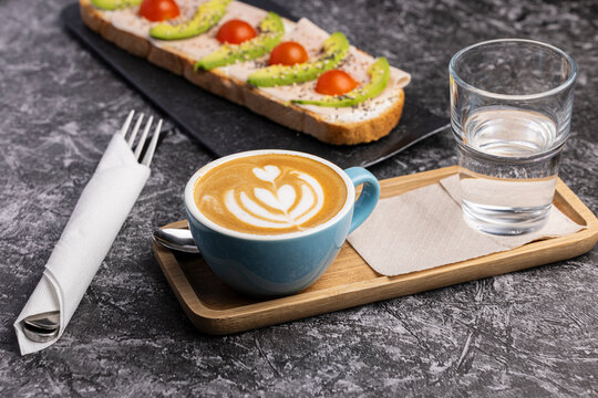 Avocado toast and latte breakfast on a rustic table