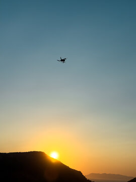 Drone silhouette above mountain at sunset sky