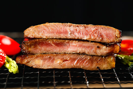 Sliced grilled beef steak with vegetables on a wire rack