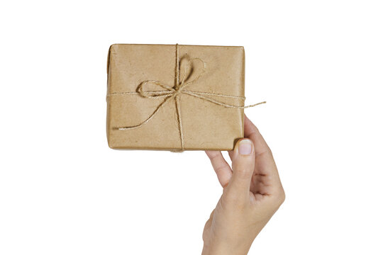 Wrapped Gift in Brown Paper Held by Hands Tied With Twine for Eco-Friendly Giving