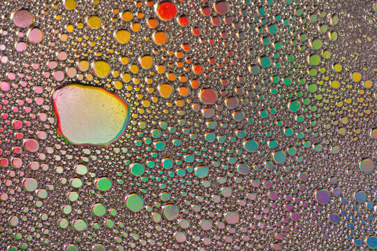 Colorful abstract oil droplet pattern on textured surface