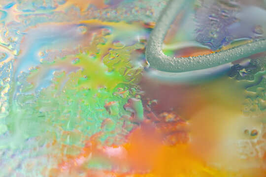 Colorful abstract liquid texture with iridescent water droplets