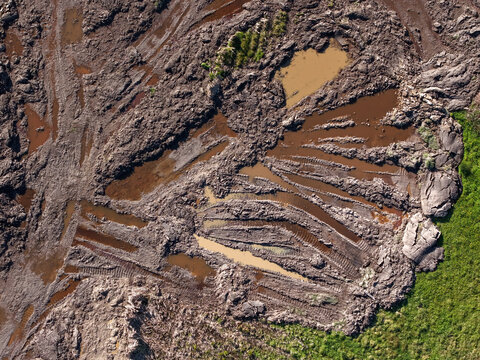 Aerial view of muddy field with tire track patterns