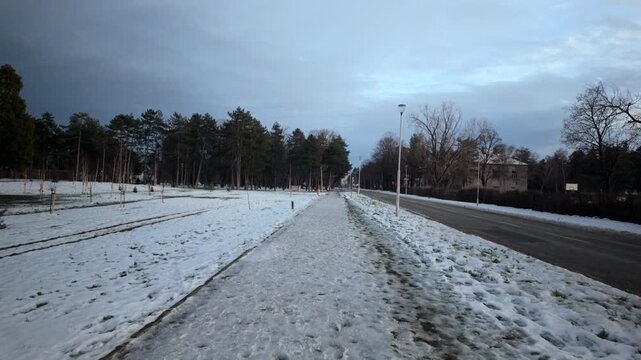 Snow Covered Park Path Beside Quiet Winter Road
