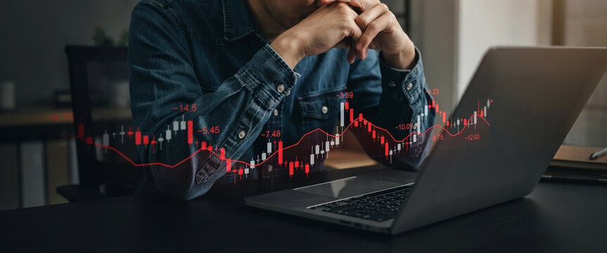Financial analyst looking at falling stock market candle charts showing investment losses and economic market downturn trends.