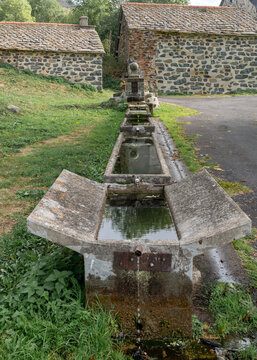 France: a long succession of stone troughs serving as a fountain and watering place, located in the village of Le Vernet in the Auvergne-Region.