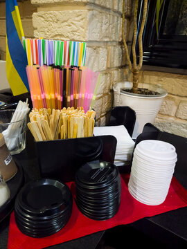 Coffee shop counter drinking straws wooden stirrers cup lids napkins cafe accessories red tray stone wall interior service