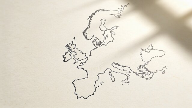 Displaying hand-drawn Europe map in black ink resting on cream paper with soft shadow