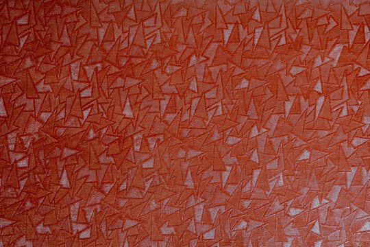 textured triangular surface pattern with interlocking geometry and reddish brown sheen