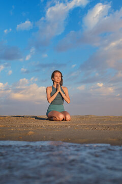 Beach scene featuring a woman, yoga, vajrasana, thunderbolt pose, meditating, and prayer pose