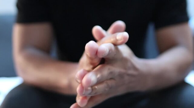 Anxious man cracking his knuckles showing stress, nervousness, and tension. Body language concept of anxiety and worry