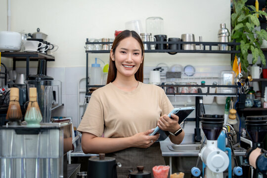Professional barista with a tablet at a modern coffee workspace.