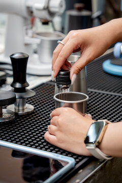 Coffee professional using a needle tool to prepare an espresso dose.