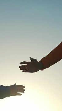 A hand reaches out towards the light in the distance, creating a silhouette against the bright sky. The hand is extended, signifying a connection or invitation to the viewer.
