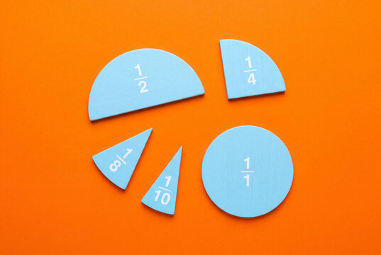 close up of blue math fractions. pie chart on a orange background. back to school
