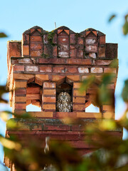 Fototapeta premium Puszczyk (zwyczajny), tawny owl, Strix aluco - w zurbanizowanym świecie, ukryty w otworze starego, ceglanego komina. Tawny owl sitting inside an old brick chimney.