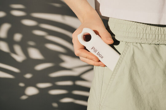 Woman carrying portable pill box in pocket for convenient medication management
