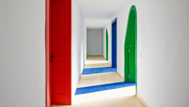 White corridor with red and green arched doors, decision problem