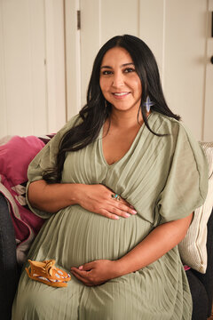 Native American pregnant woman in a cozy setting with soft colors and warm light