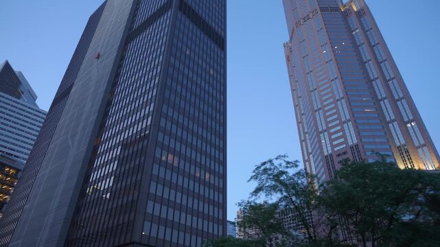 Modern office towers rise into the blue evening sky in downtown Chicago, Illinois. Urban financial district with illuminated skyscrapers and contemporary architecture creates a dramatic metropolitan