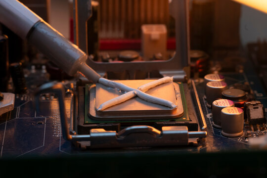 tube of thermal interface material squeezing an x pattern onto a central processing unit on a server motherboard