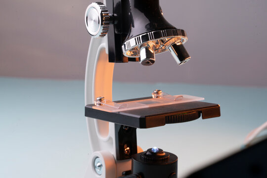 Close up of clinical microscope examining rejuvenating cream on glass slide during cosmetic quality control