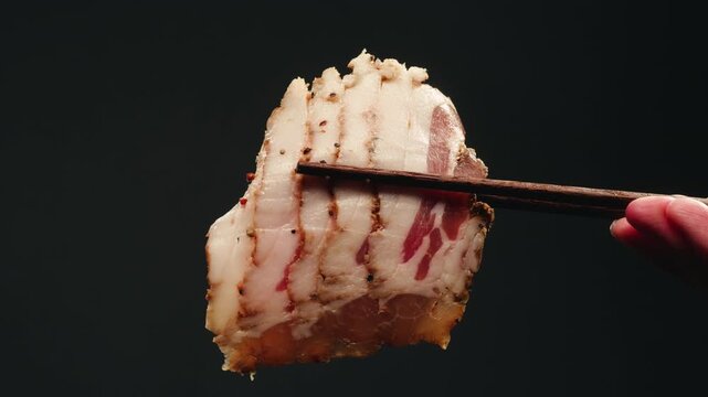 Pork belly bacon raw slices close up, fatty pork fat meat with layers of lard, unhealthy junk food high in cholesterol and saturated fat