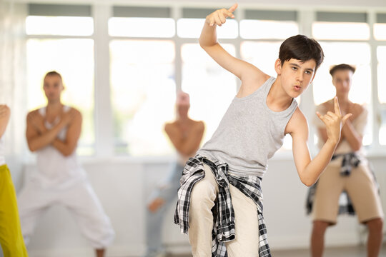 Group of young girls an boys perform choreographic exercises and teaches energetic breakdancing waacking together