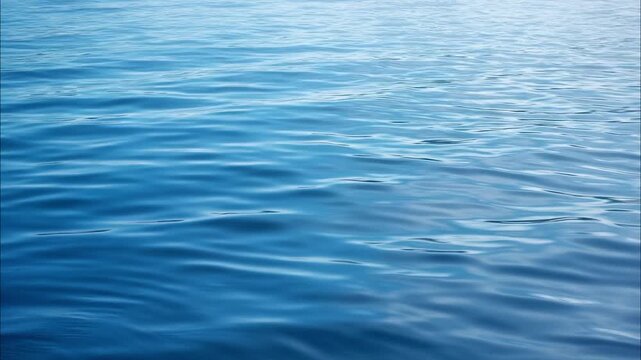 Deep blue ocean water surface with gentle calming waves rippling. Serene and tranquil natural marine sea background