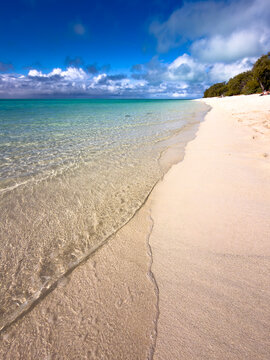 Crystal clear turquoise water laps a pristine white sand beach at Heron Island in the Great Barrier Reef, Queensland, Australia.